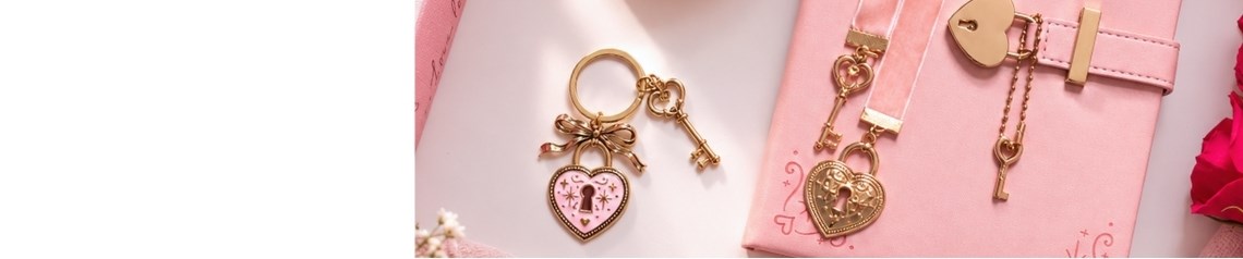 Lock and Key collection featuring pink and burgundy wholesale mugs, journals, candles, vases and keepsakes with heart, bow and key motifs in a romantic Valentine’s Day style.